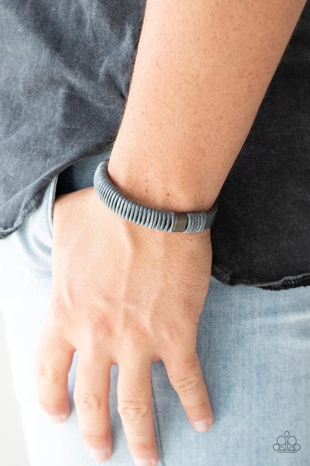 Paparazzi Accessories What Happens On The Road ~Silver Infused with metallic accents, shiny gray cording wraps around a gray leather band for an urban look. Features an adjustable snap closure. Sold as one individual bracelet.