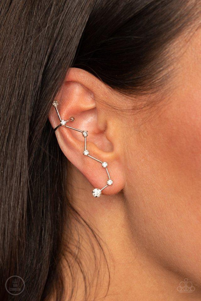 Paparazzi Accessories Constellation Prize - White Dotted with dainty white rhinestones, zigzagging silver bars delicately climb the ear, creating a sparkly constellation. Earring attaches to a standard post fitting. Features a dainty cuff attached to the