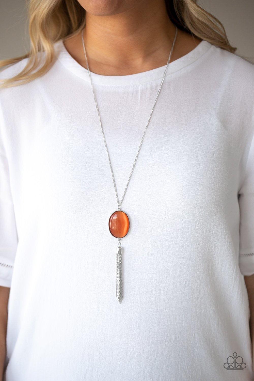 Paparazzi Accessories Tasseled Tranquility - Orange An oversized orange cat's eye stone frame gives way to a shimmery silver chain tassel, creating a whimsically stacked pendant at the bottom of a lengthened silver chain. Features an adjustable clasp clos