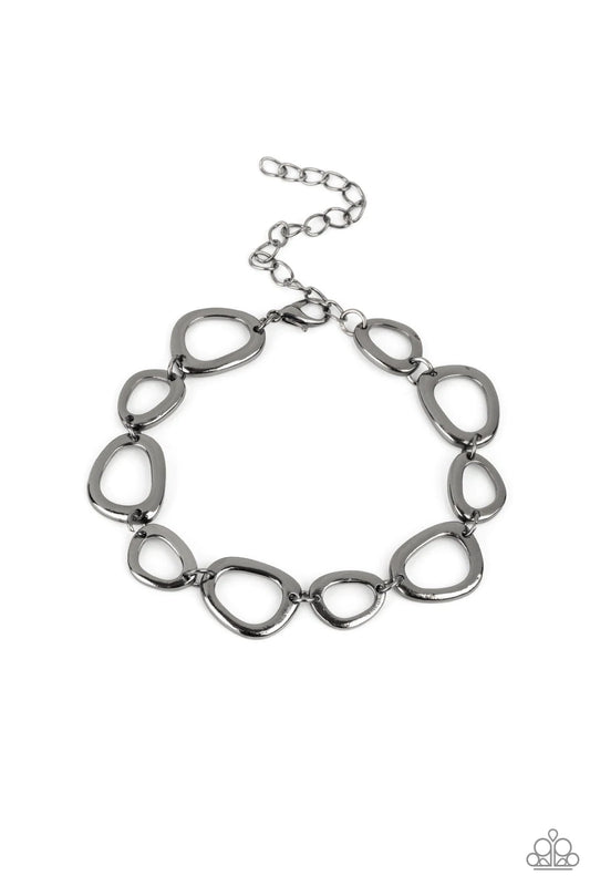 Paparazzi Accessories All That Mod - Black An array of irregular shaped gunmetal rings link together and make their way around the wrist for a simple yet stylish avant-garde fashion. Features an adjustable clasp closure. Sold as one individual bracelet. J