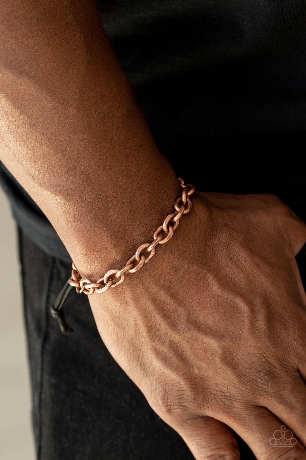 Paparazzi Accessories Rumble - Copper Shiny black cording knots around the ends of a copper beveled cable chain that is wrapped across the top of the wrist for a versatile look. Features an adjustable sliding knot closure. Jewelry