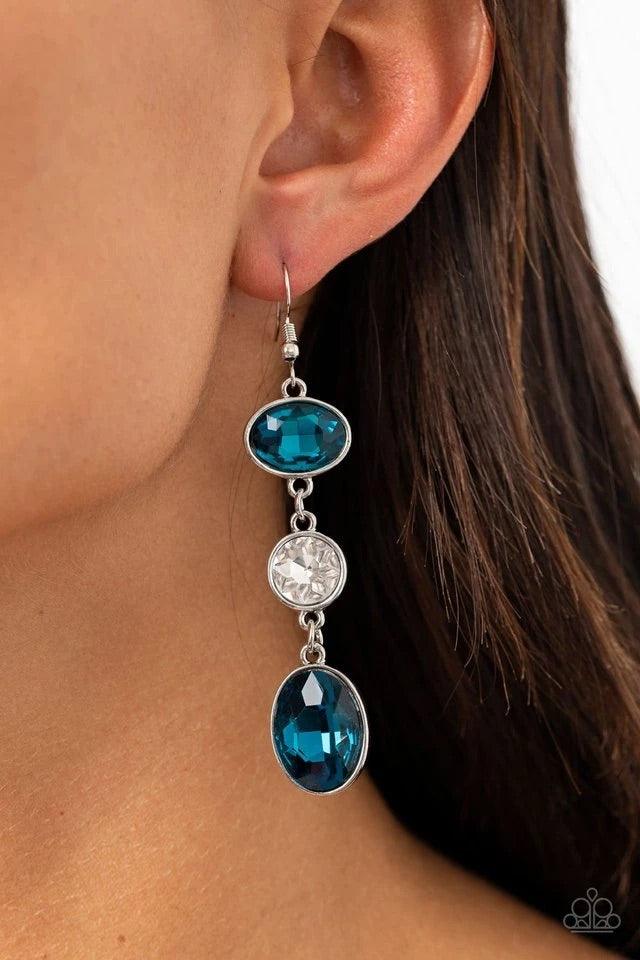 Paparazzi Accessories The GLOW Must Go On! - Blue Encased in sleek silver frames, mismatched blue oval and round white rhinestones trickle from the ear, creating an elegant lure. Earring attaches to a standard fishhook fitting. Sold as one pair of earring
