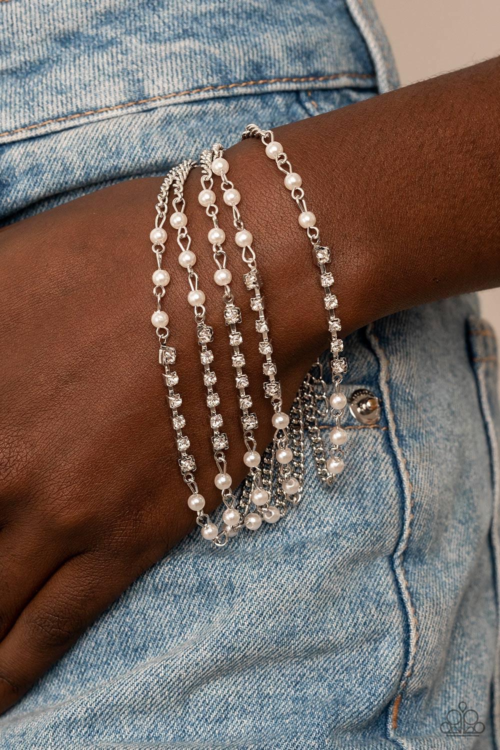 Paparazzi Accessories Experienced Elegance - White Held together with white rhinestone encrusted silver fittings, sections of dainty white pearls and glassy white rhinestones delicately connect to classic silver chains around the wrist for a timelessly la