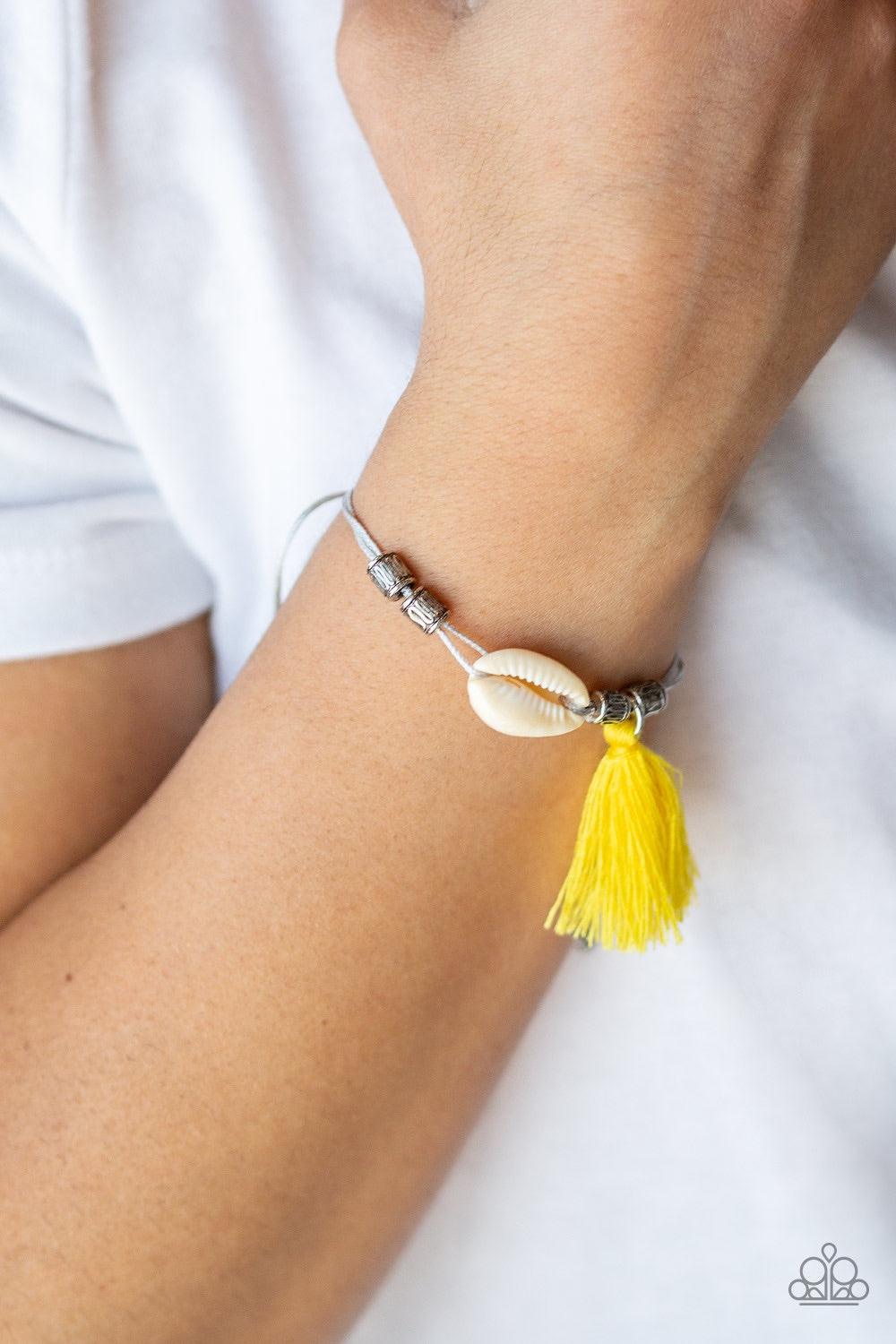 Paparazzi Accessories SEA If I Care - Yellow Infused with antiqued silver beads, a yellow threaded tassel and dainty white seashell slide along strips of shiny gray cording around the wrist for a summery look. Features an adjustable sliding knot closure.