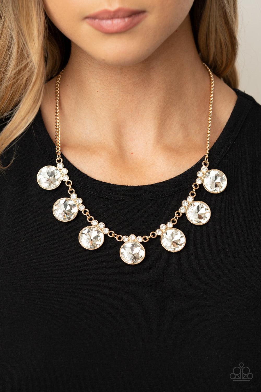 Paparazzi Accessories GLOW-Getter Glamour - Gold Crowned in a trio of dainty white rhinestones, an exaggerated display of oversized white gems delicately link below the collar for a glamorous glow. Features an adjustable clasp closure. Sold as one individ