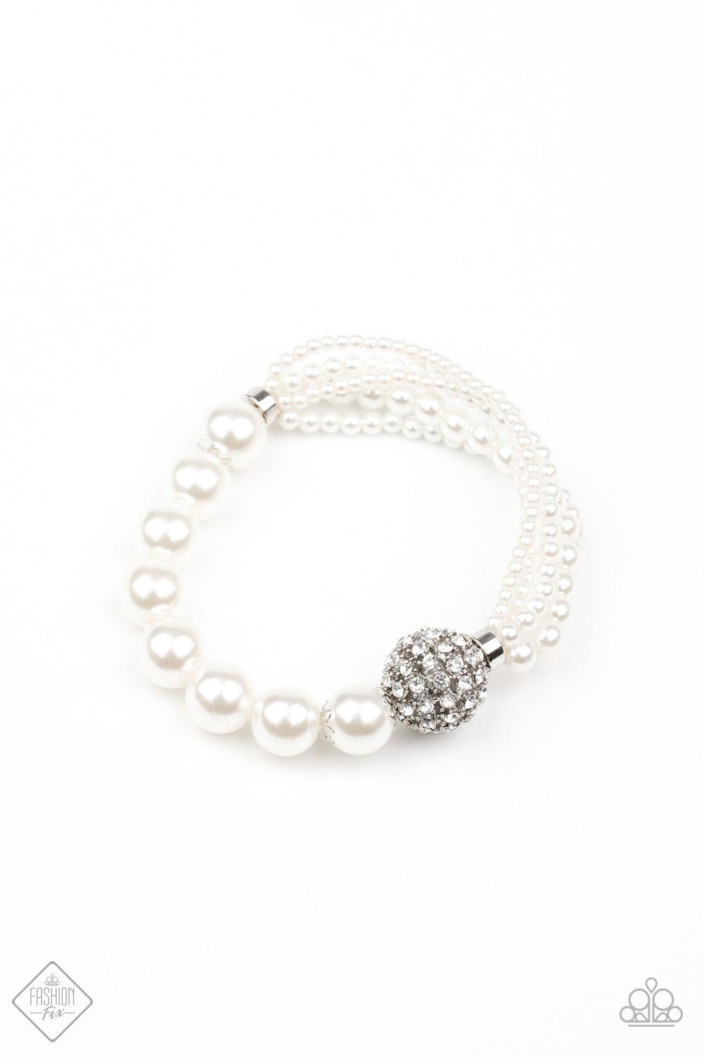 Paparazzi Accessories Show Them The DIOR! - White Featuring comfortable stretchy bands, a white rhinestone-encrusted silver bead connects strands of mismatched white pearls and a single strand of classic white pearls around the wrist in a timeless twist.