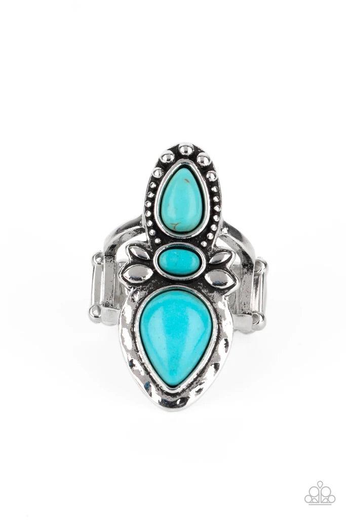 Paparazzi Accessories In a BADLANDS Mood - Blue Two refreshing turquoise stone teardrops flank a dainty oval turquoise stone and decoratively studded and hammered silver frame, creating a rustic statement piece atop the finger. Features a stretchy band fo