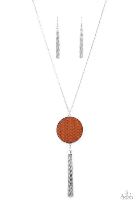 Paparazzi Accessories Wondrously Woven - Brown Featuring a faux woven finish, a shiny piece of Adobe leather is pressed into a studded circular frame at the bottom of a lengthened silver chain. Capped in a frame, a silver chain tassel streams out from the