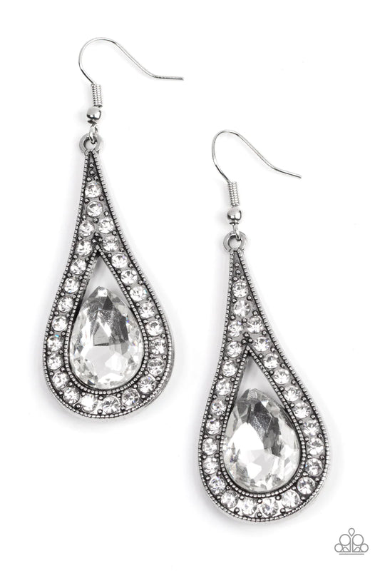 Paparazzi Accessories A-Lister Attitude - White An oversized white teardrop gem is nestled inside the bottom of a ribbon of glittery white rhinestones, creating a dramatic lure. Earring attaches to a standard fishhook fitting. Sold as one pair of earrings