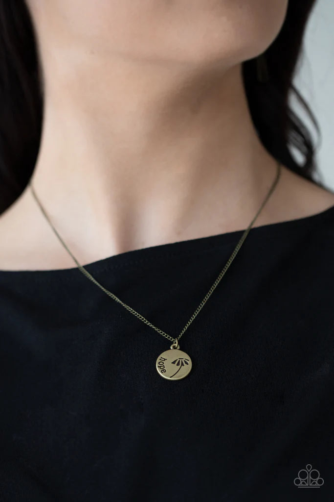 Paparazzi Accessories Hold On To Hope - Brass Stamped in a whimsical flower, a dainty brass disc is stamped in the word, "Hope," creating an inspirational pendant below the collar. Features an adjustable clasp closure. Sold as one individual necklace. Inc