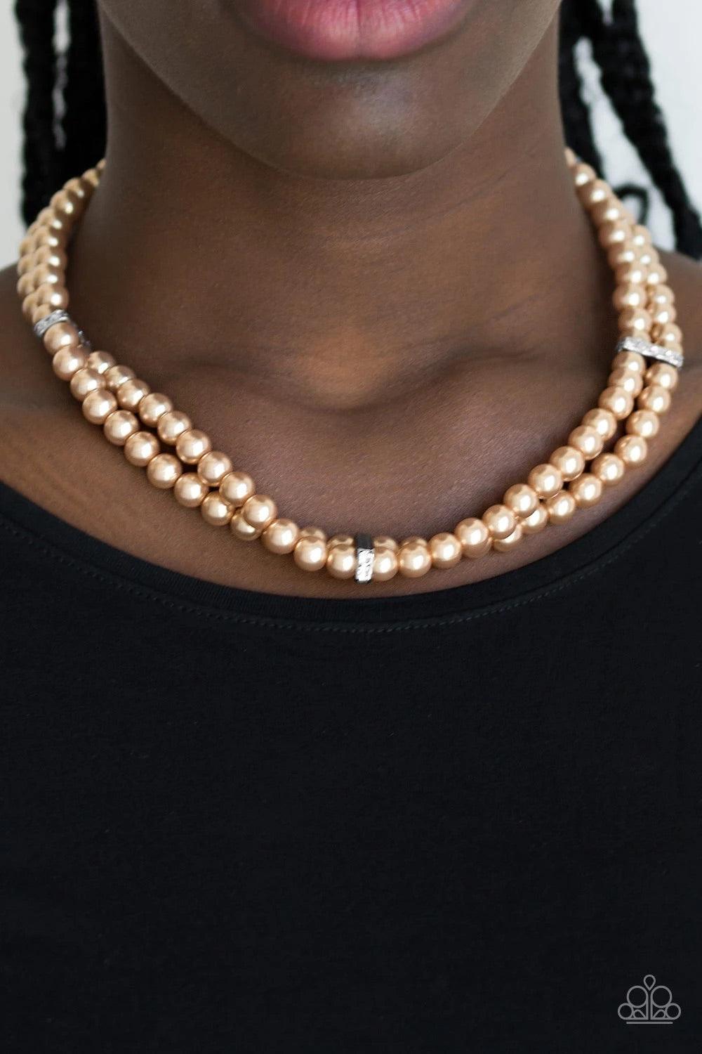 Paparazzi Accessories Put on Your Party Dress - Brown Pinched between white rhinestone encrusted frames, strands of classic brown pearls layer below the collar for a timeless look. Features an adjustable clasp closure. Sold as one individual necklace. Inc