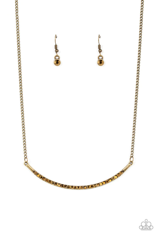 Paparazzi Accessories Collar Poppin’ Sparkle - Brass Encrusted in glitzy aurum rhinestones, a curved brass bar bows below the collar for a smoldering style. Features an adjustable clasp closure. Sold as one individual necklace. Includes one pair of matchi