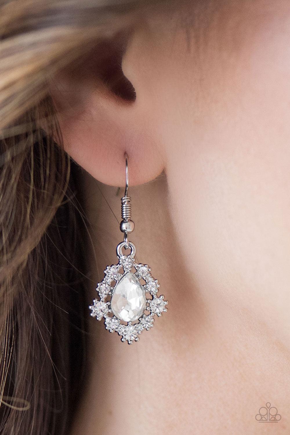 Paparazzi Accessories Rich And Regal - White Dainty white rhinestones dance around a shimmery white teardrop, creating a regal frame. Earring attaches to a standard fishhook fitting. Jewelry