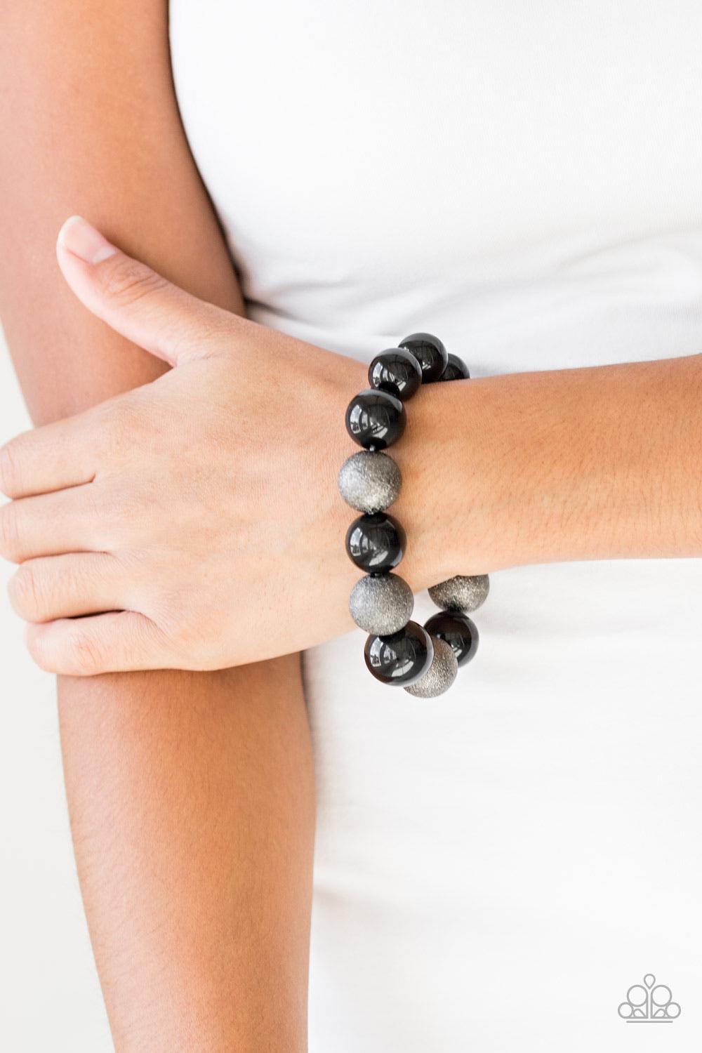 Paparazzi Accessories Humble Hustle - Black Dusted in glitter, sparkling gunmetal and shiny black beads are threaded along a stretchy band around the wrist for a glamorous look. Sold as one individual bracelet. Jewelry