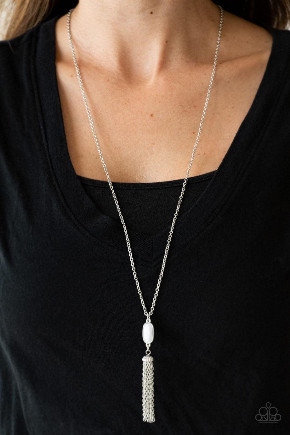 Paparazzi Accessories Tassel Tease - White Swinging from a lengthened silver chain, a faceted white bead gives way to a shimmery silver tassel for a whimsical look. Features an adjustable clasp closure. Sold as one individual necklace. Includes one pair o