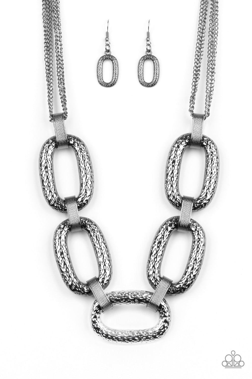Paparazzi Accessories Take Charge - Black Delicately hammered in blinding shimmer, oversized shiny gunmetal chain links and textured fittings connect below the collar. Suspended from strands of gunmetal chains, the bold links catch and reflect the light f