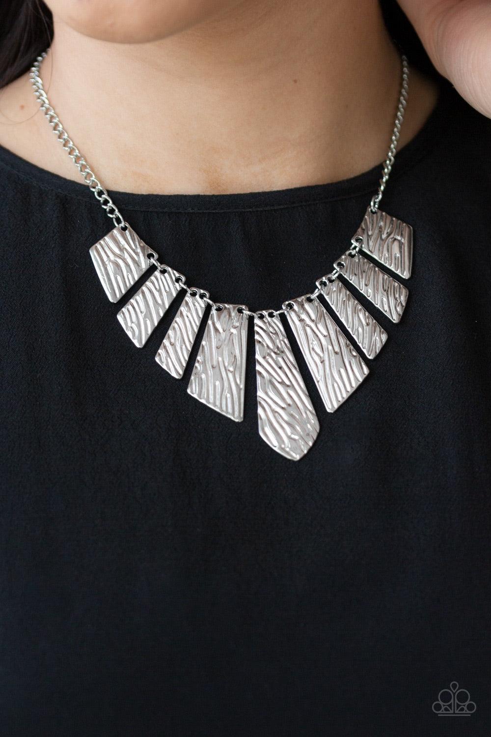 Paparazzi Accessories Texture Tigress - Silver Embossed in rippling patterns, a collection of angular silver plates swing from the bottom of a glistening silver chain, creating an edgy geometric fringe below the collar. Features an adjustable clasp closur