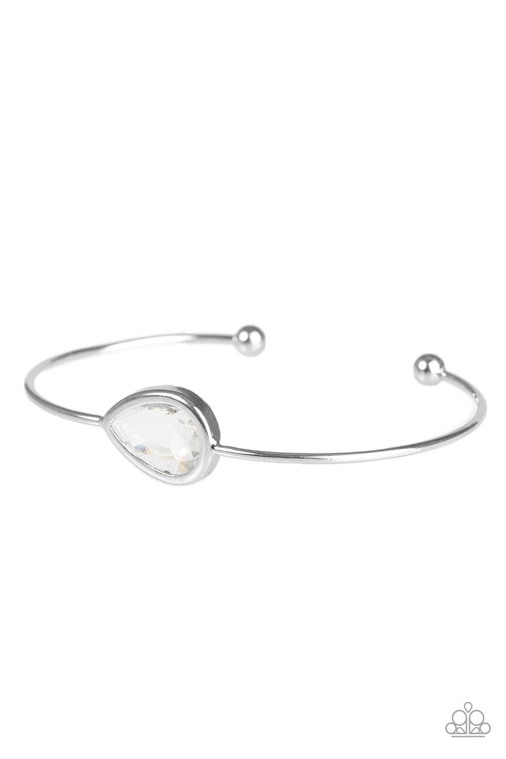 Paparazzi Accessories Make A Spectacle - White A glassy white gem is pressed into a teardrop fitting in the center of a dainty silver cuff for a refined look. Jewelry