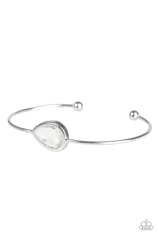 Paparazzi Accessories Make A Spectacle - White A glassy white gem is pressed into a teardrop fitting in the center of a dainty silver cuff for a refined look. Jewelry