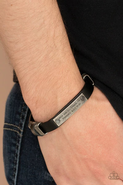 Paparazzi Accessories Make It Possible - Black A silver frame is stamped in the bible passage, "With God all things are possible, Matt 19:26," is studded in place across the front of a black leather band, gunmetal rings are added to the display for a rust