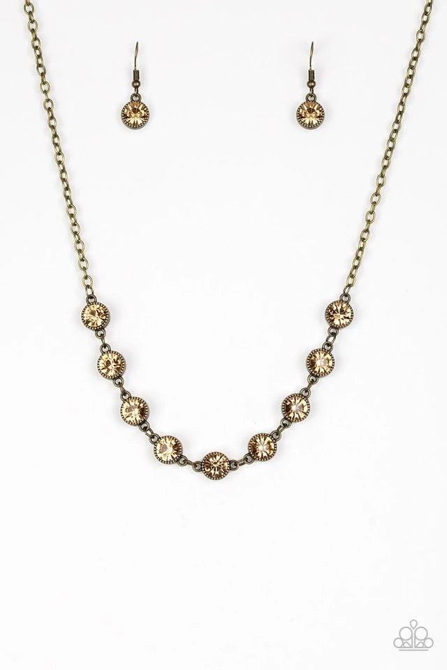 Paparazzi Accessories Starlit Socials - Brass Encased in studded brass frames, golden topaz rhinestones link below the collar for a glamorous look. Features an adjustable clasp closure. Sold as one individual necklace. Includes one pair of matching earrin