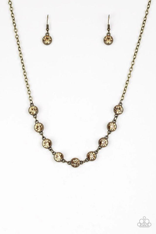 Paparazzi Accessories Starlit Socials - Brass Encased in studded brass frames, golden topaz rhinestones link below the collar for a glamorous look. Features an adjustable clasp closure. Sold as one individual necklace. Includes one pair of matching earrin