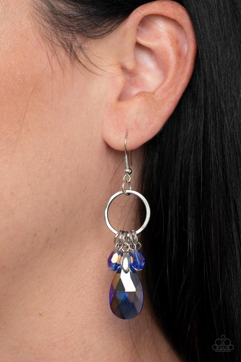 Paparazzi Accessories Unapologetic Glow ~Blue An oversized iridescent blue crystal-like teardrop swings from the bottom of a dainty silver hoop embellished with matching crystal-like beads, creating a glamorous fringe. Earring attaches to a standard fishh