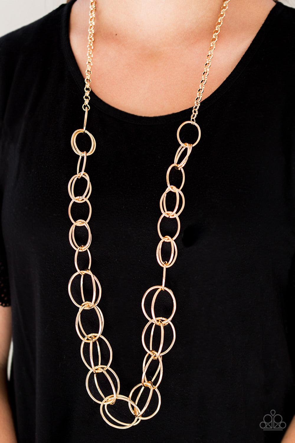Paparazzi Accessories Elegantly Ensnared - Gold Gradually increasing in size, a collection of bold gold hoops link to a dramatically interconnected chain for a statement-making look. Features an adjustable clasp closure. Jewelry