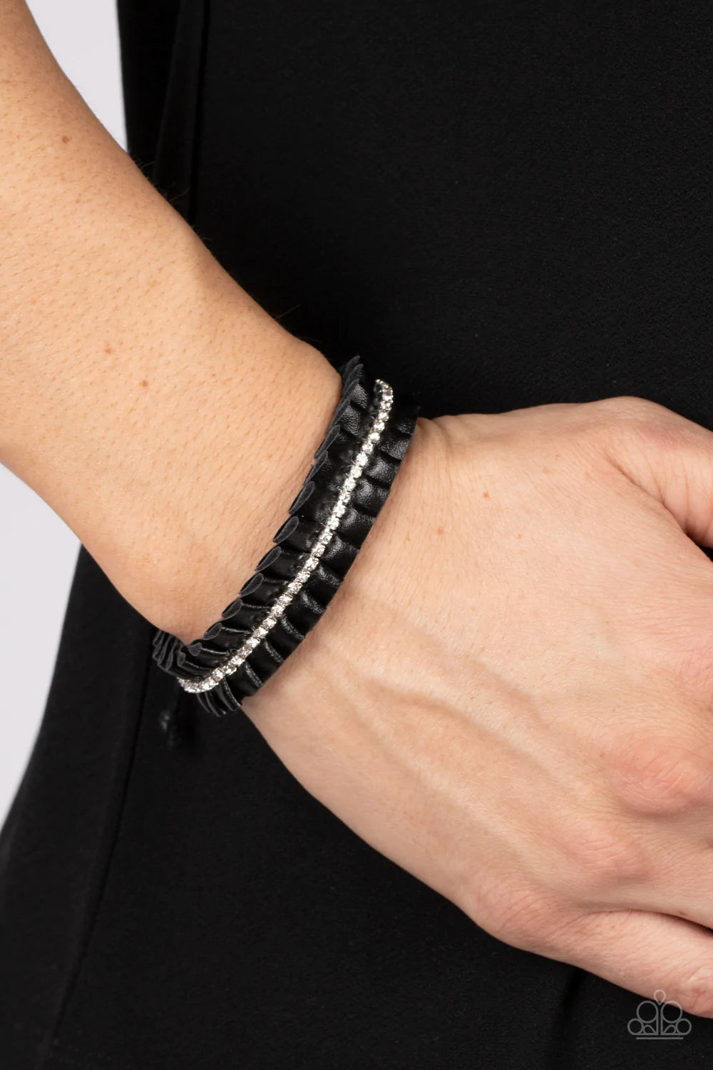 Paparazzi Accessories Pretty, Pretty PLEATS - Black A black leather ribbon delicately gathers into pleats around the wrist. A glittery strand of white rhinestones adorns the center of the pleats, adding a glitzy accent to the textured centerpiece. Feature