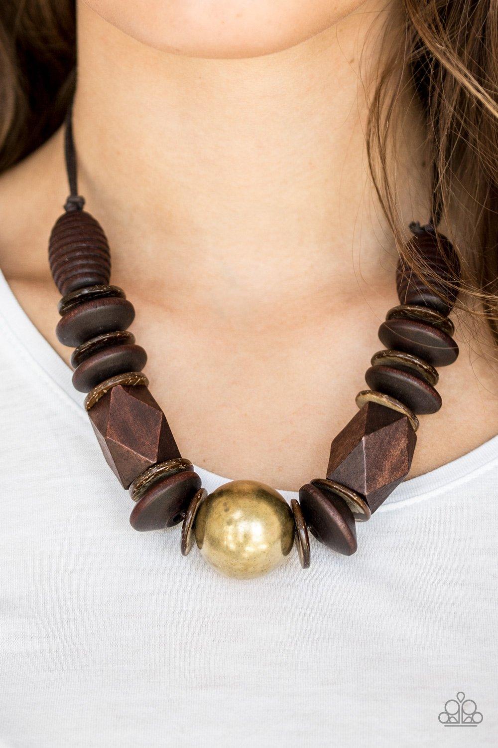 Paparazzi Accessories Grand Turks Getaway - Brass Featuring abstract geometric finishes, mismatched brown wooden beads are threaded along shiny brown cording. A dramatic copper bead adorns the center, creating a bold seasonal look below the collar. Featur