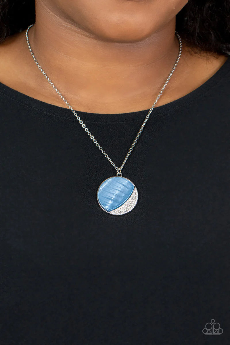 Paparazzi Accessories Oceanic Eclipse - Blue A refreshingly blue Spring Lake shell-like pendant is eclipsed in a half moon silver frame that is encrusted in sparkly white rhinestones, creating a shimmery display below the collar. Features an adjustable cl