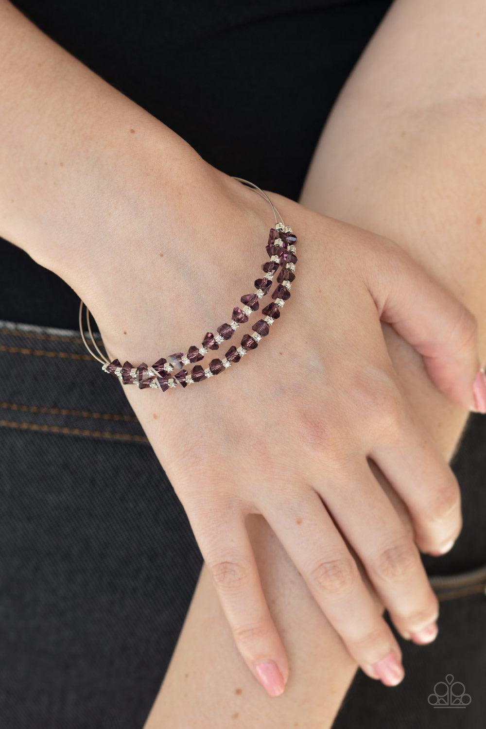 Paparazzi Accessories Prismatic Posh - Purple Featuring jagged cuts, a collection of faceted purple crystal-like beads and dainty white rhinestones are encrusted along the tops of two silver wires, coalescing into a glamorous cuff. Jewelry
