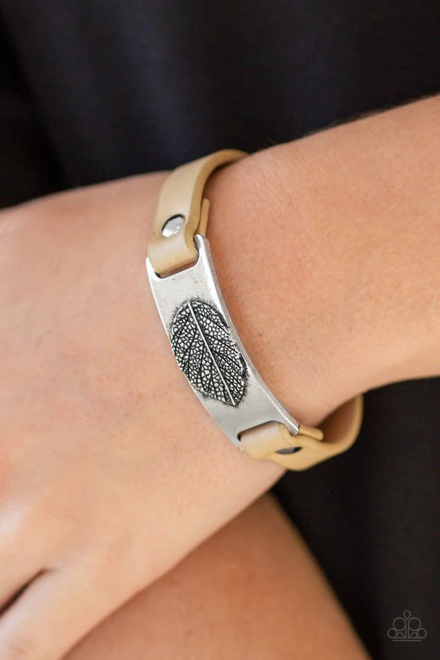 Paparazzi Accessories Take The LEAF - Brown Brushed in an antiqued finish, a life-like leaf is embossed in the center of a silver plate. Soybean leather bands loop through the silver centerpiece and are studded in place across the wrist for a seasonal loo