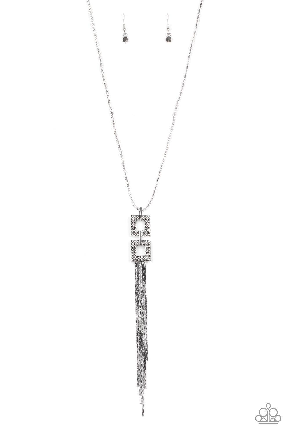 Paparazzi Accessories Times Square Stunner - Silver Encrusted in smoky hematite rhinestones, two squared, silver frames link at the bottom of a lengthened silver box chain. Flattened silver chains stream from the bottom of the stacked pendant, creating an