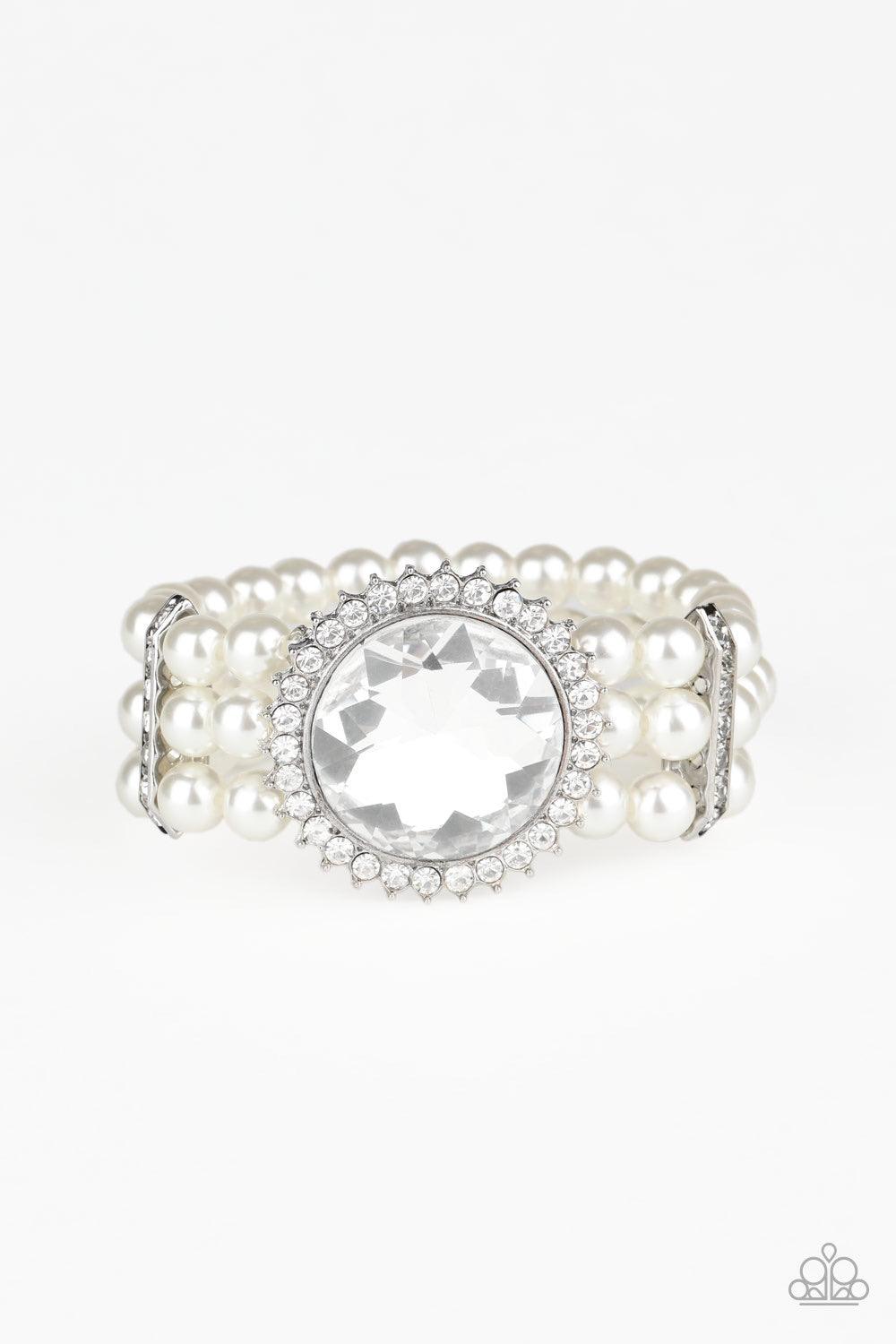 Paparazzi Accessories Speechless Sparkle - White Threaded along stretchy bands, strands of pearly white beads are held in place with white rhinestone encrusted fittings around the wrist. Bedazzled in a ring of glassy white rhinestones, a dramatically over