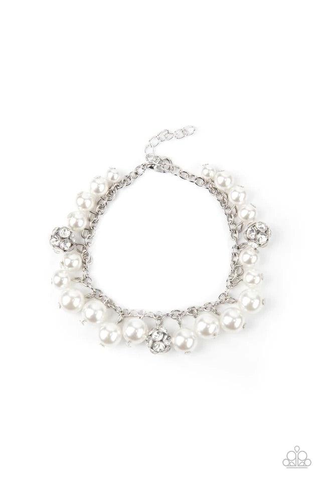 Paparazzi Accessories The GRANDEUR Tour - White A timeless collection of bubbly white pearls and white rhinestone encrusted silver beads swing from a classic silver chain, creating a refined fringe. Features an adjustable clasp closure. Bracelets