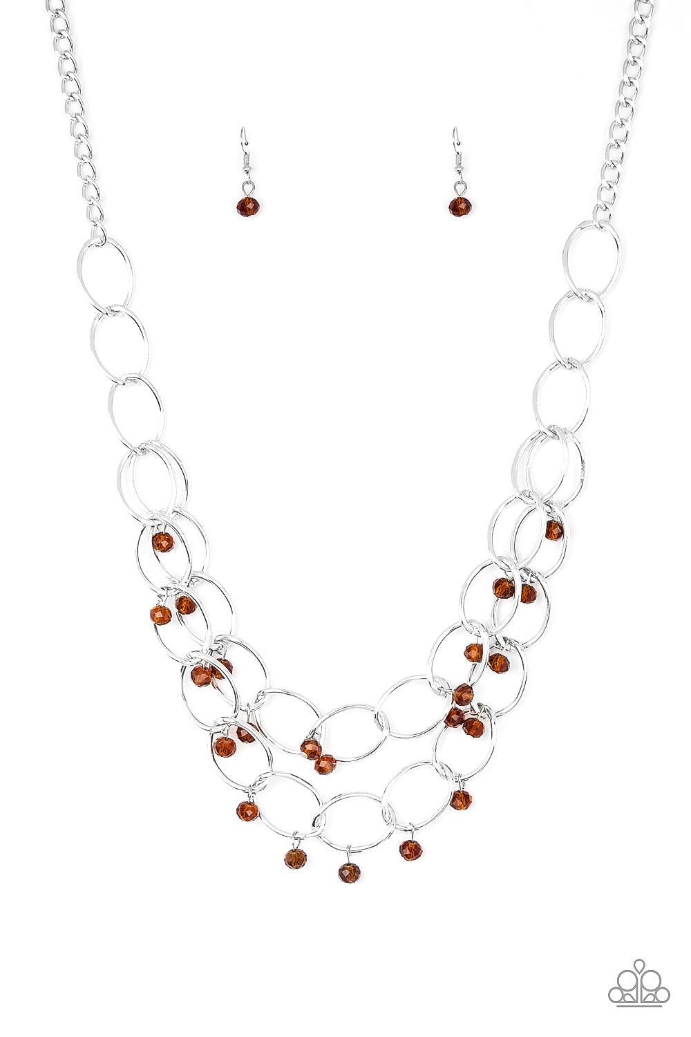 Paparazzi Accessories Yacht Tour - Brown Shimmery brown crystal-like beads swing from two layers of oversized silver links below the collar for a refined look. Features an adjustable clasp closure. Sold as one individual necklace. Includes one pair of mat