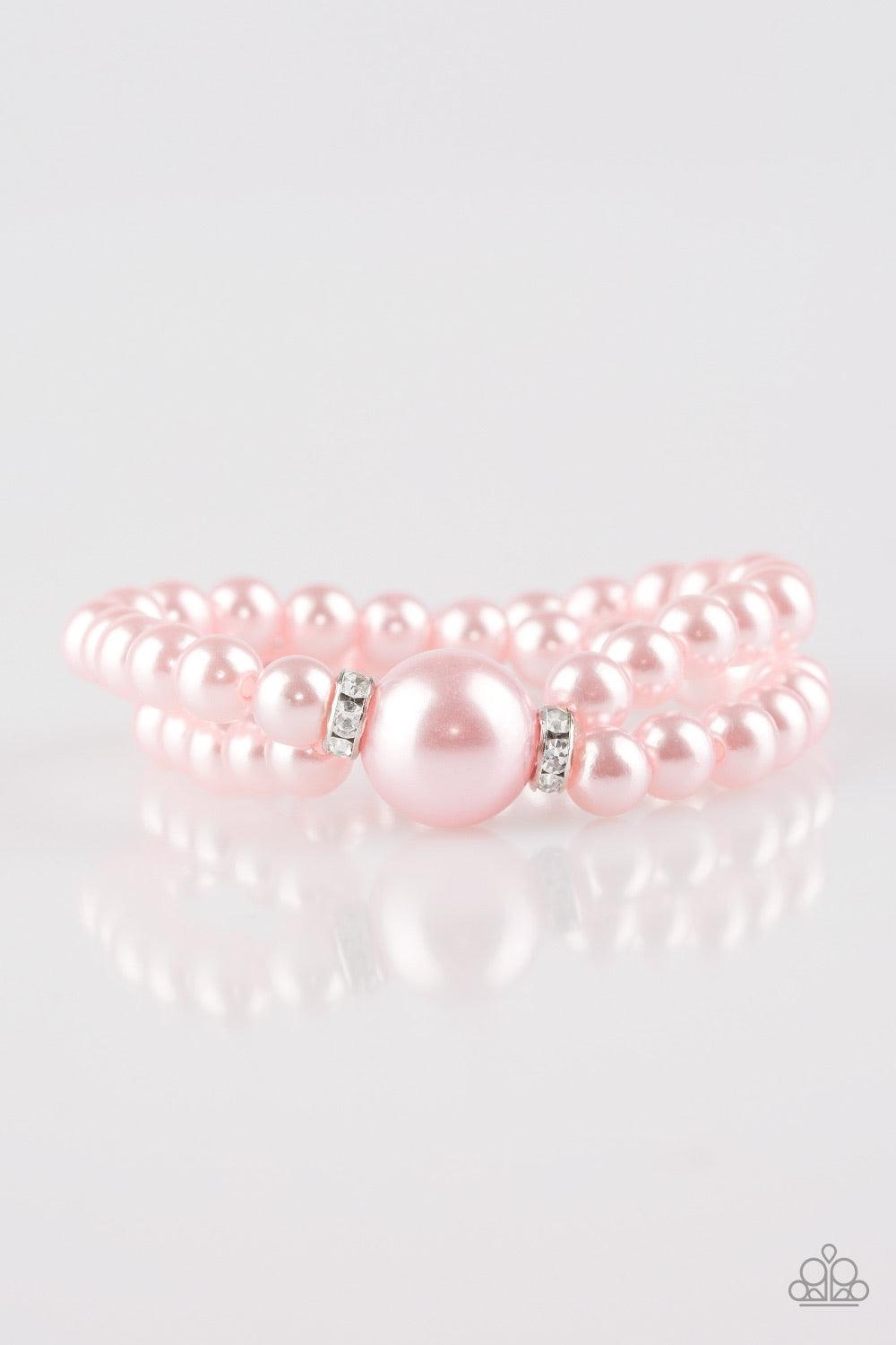 Paparazzi Accessories Romantic Redux - Pink Joined at the center by an oversized pink pearl and a pair of white rhinestone encrusted rings, classic pink pearls are threaded along stretchy bands around the wrist for a timelessly layered look. Jewelry