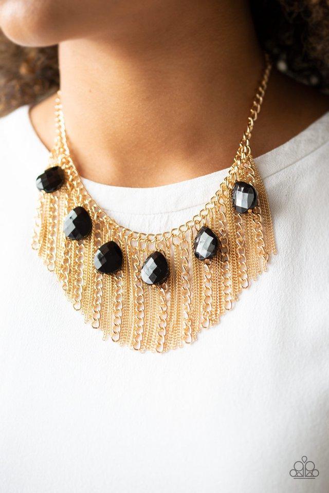 Paparazzi Accessories Vixen Conviction - Gold Infused with a row of faceted black teardrops, mismatched strands of gold chains stream from the bottom of a glistening gold chain, creating a statement-making fringe below the collar. Features an adjustable c