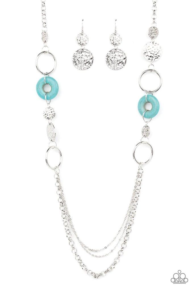 Paparazzi Accessories Grounded Glamour - Blue An earthy collection of hammered silver discs, turquoise stone accents, and bold silver hoops link with sections of chunky and mismatched silver chains across the chest, creating a seasonal display. Features a