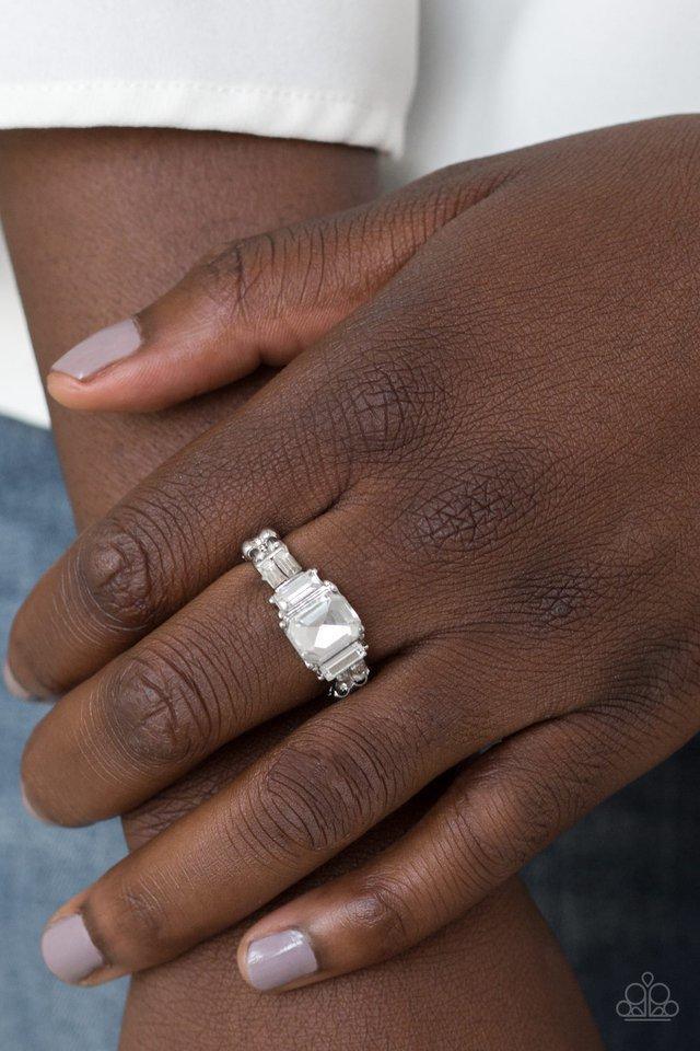 Paparazzi Accessories Born to Rule - White Varying in cut and shimmer, glittery white rhinestones stack into a glamorous band across the finger. Features a dainty stretchy band for a flexible fit.Sold as one individual ring. Jewelry