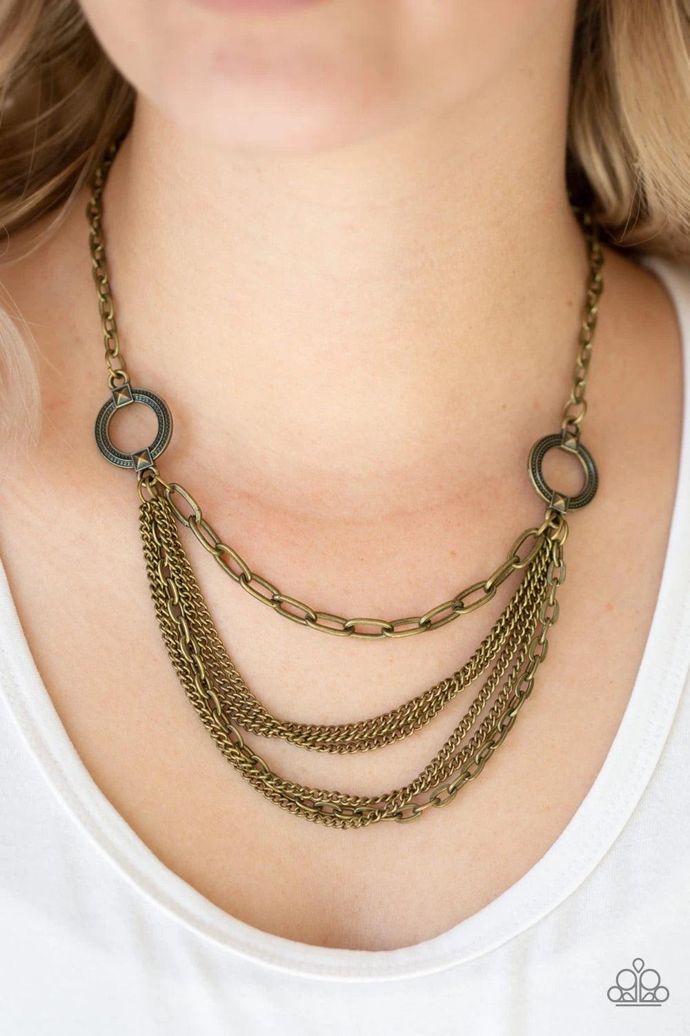 Paparazzi Accessories CHAINS of Command - Brass Ornate brass hoops give way to mismatched brass chains below the collar for an edgy industrial look. Features an adjustable clasp closure. Sold as one individual necklace. Includes one pair of matching earri