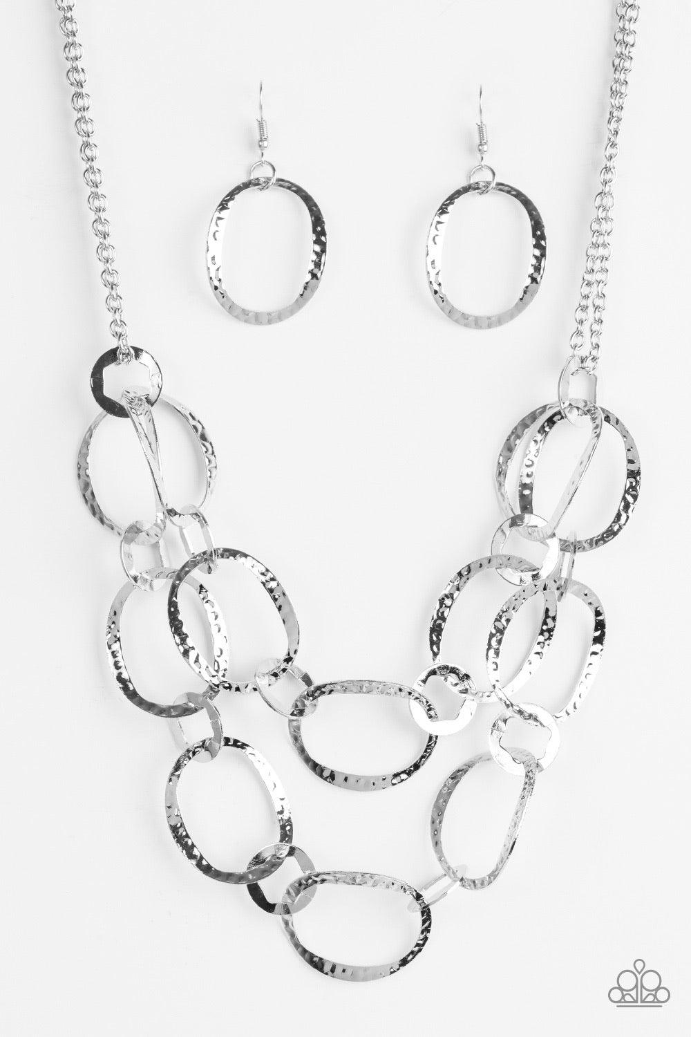 Paparazzi Accessories Circus Chic - Silver Featuring hexagonal centers, dainty silver rings link together two rows of hammered silver frames. The layered rows drape just below the collar for a refined look. Features an adjustable clasp closure. Sold as on