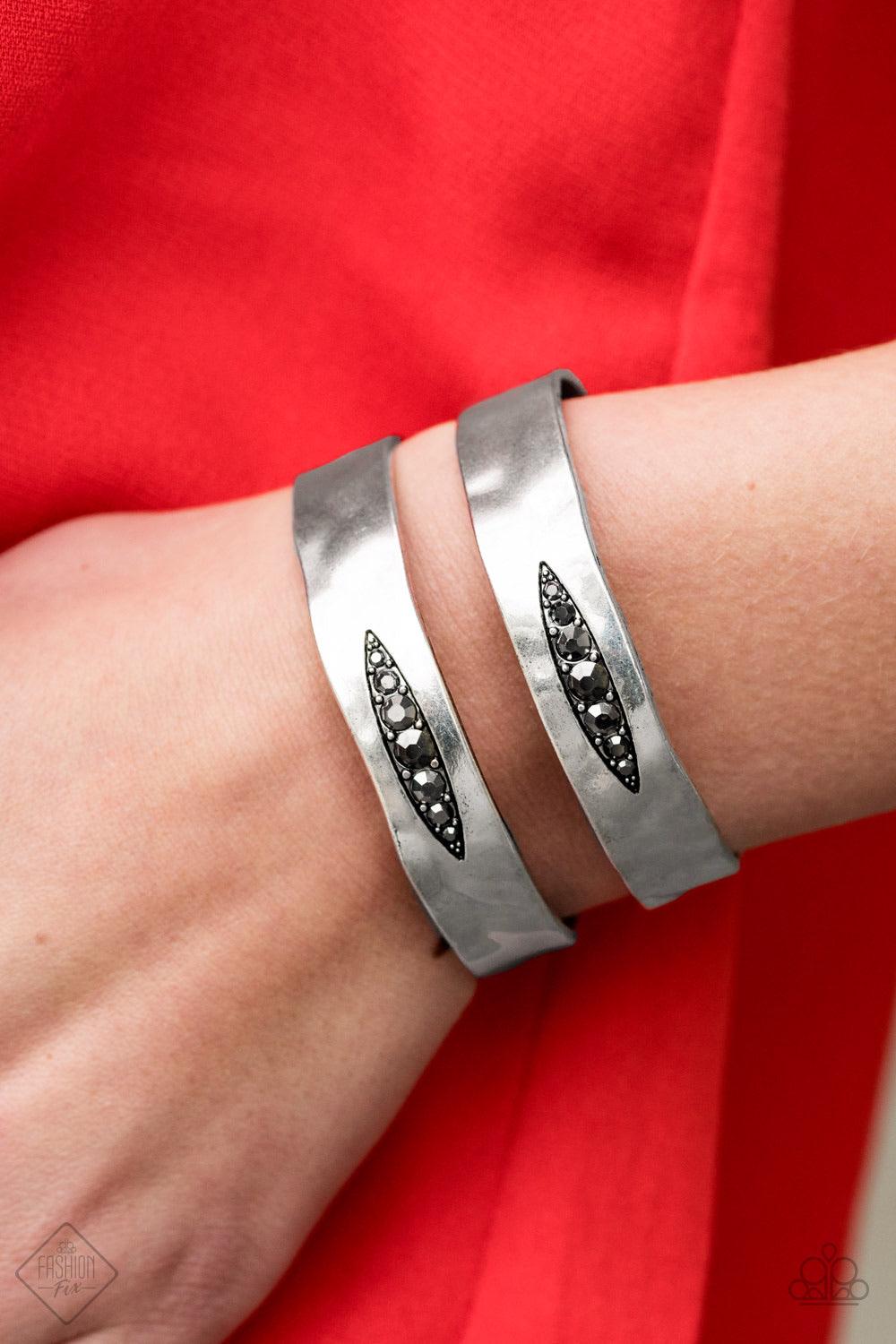 Paparazzi Accessories In HAUTE Pursuit ~Black Hammered silver bars arc across the wrist, combining into a bold cuff. A marquise-shaped cutout is filled with glittery hematite rhinestones along the centers of the cuff in an edgy finish. Sold as one individ