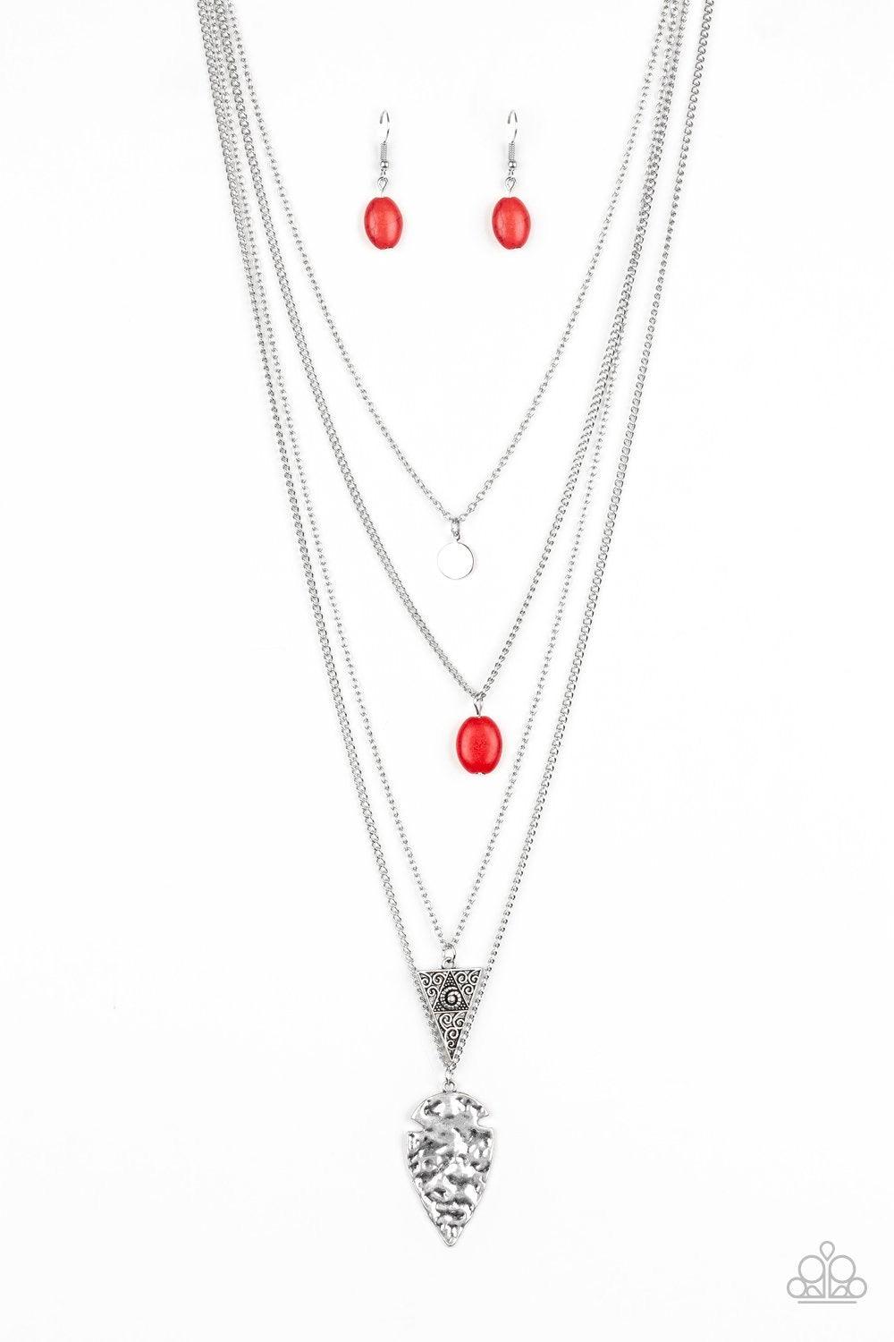 Paparazzi Accessories Grounded in ARTIFACT - Red Glistening silver chains drape across the chest, creating four shimmery layers. A dainty silver disc swings from the uppermost layer above a fiery red stone, ornate triangular frame, and hammered silver arr