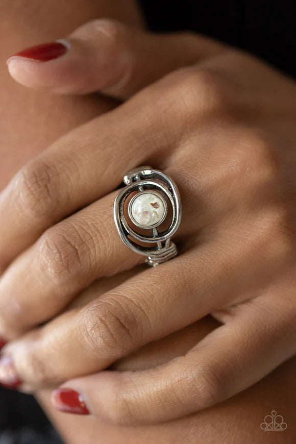 Paparazzi Accessories Celestial Karma - White Glistening silver bars swirl around a glassy white bead flecked in iridescent shell, creating an ethereal centerpiece atop the finger. Features a dainty stretchy band atop the finger. Sold as one individual ri