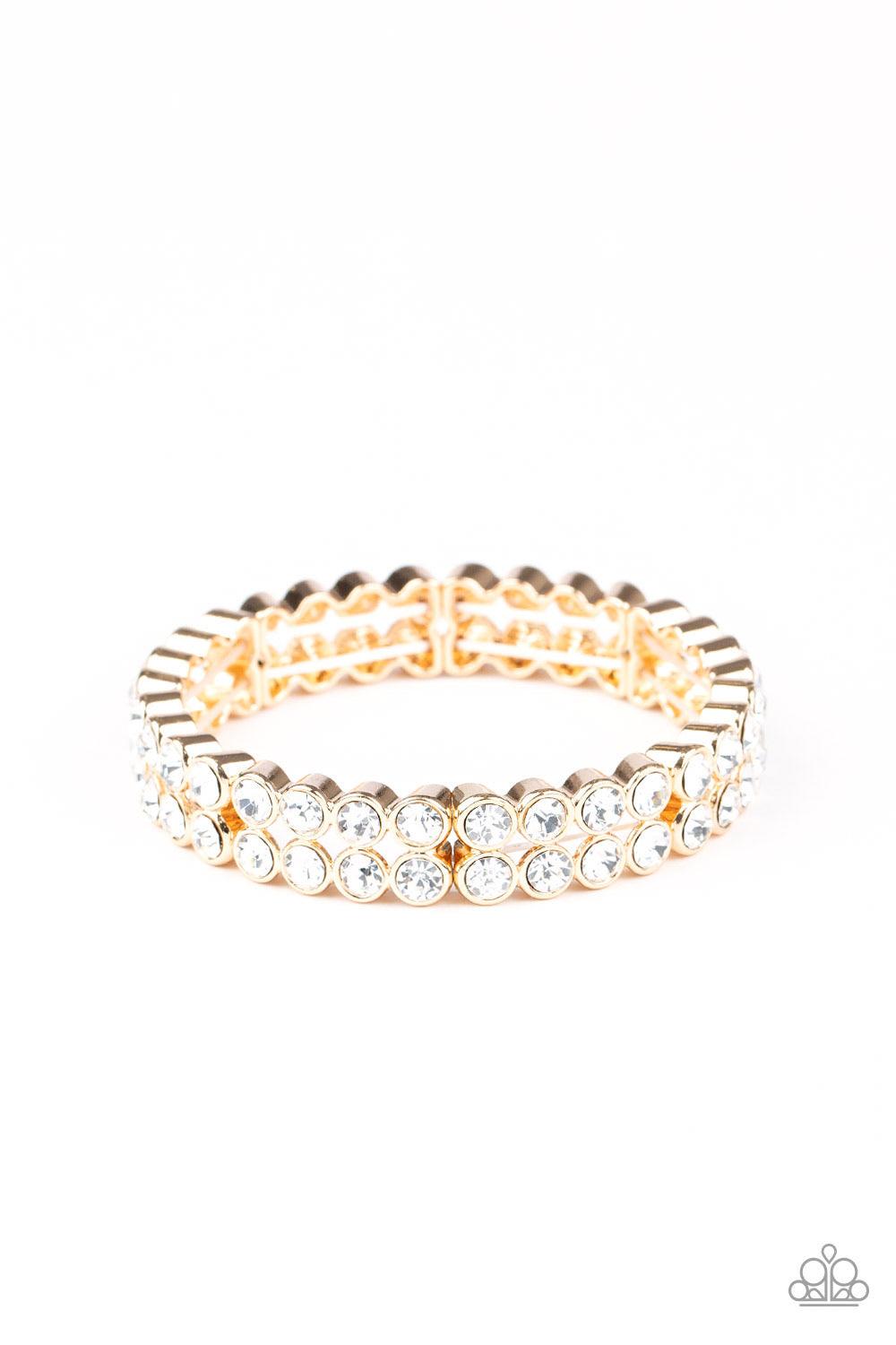 Paparazzi Accessories Come And Get It! - Gold Pairs of glittery white rhinestones stack into sections of blinding frames that have been threaded along a stretchy band around the wrist for a glamorous look. Sold as one individual bracelet. Jewelry