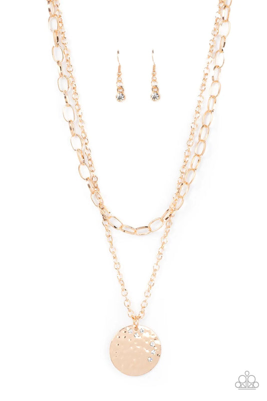 Paparazzi Accessories Highlight of My Life - Gold Sporadically dotted in glittery white rhinestones, an oversized hammered gold disc is suspended from the lowermost of two mismatched gold chains below the collar for a retro look. Features an adjustable cl