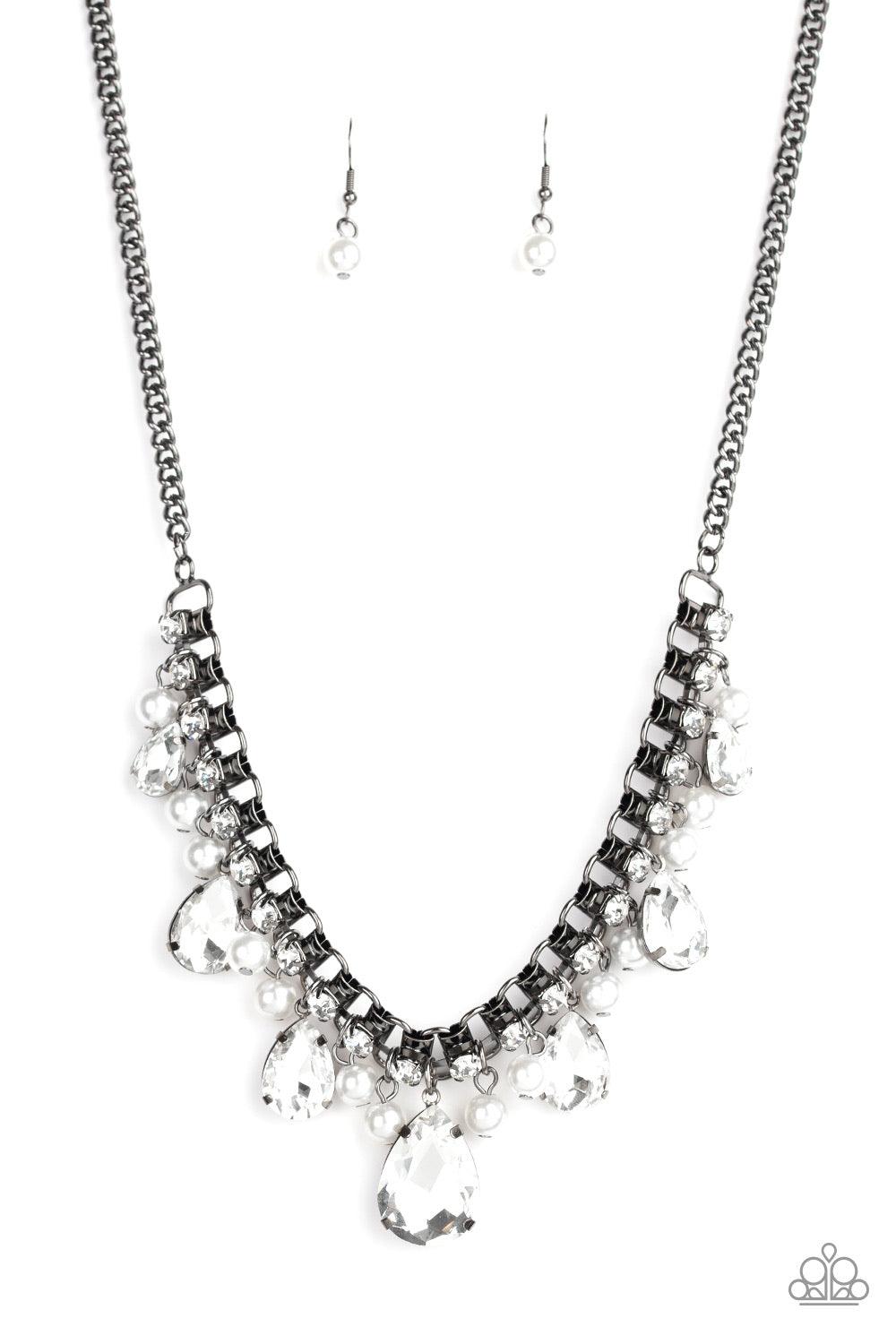 Paparazzi Accessories Knockout Queen - Black A glamorous collection of bubbly white pearls and exaggerated white teardrop gems dangle from a bold strand of white rhinestones, creating a knockout fringe below the collar. Features an adjustable clasp closur