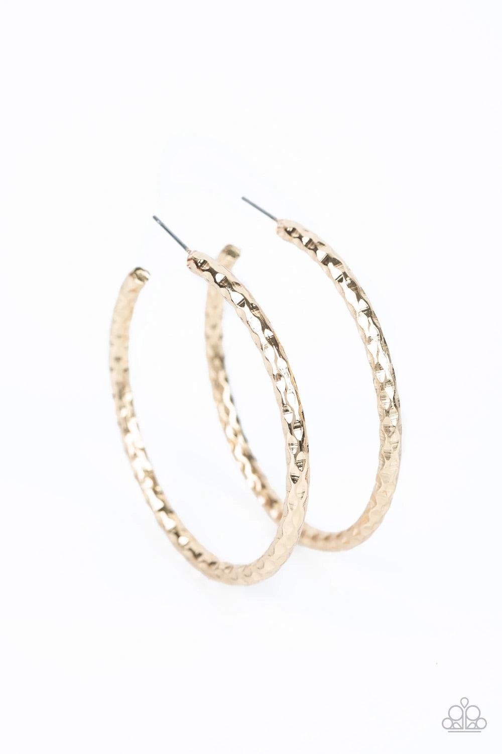 Paparazzi Accessories Urban Upgrade - Gold Hammered in blinding shimmer, a thick gold hoop curls around the ear for an edgy, urban look. Earring attaches to a standard post fitting. Hoop measures approximately 2" in diameter. Sold as one pair of hoop earr